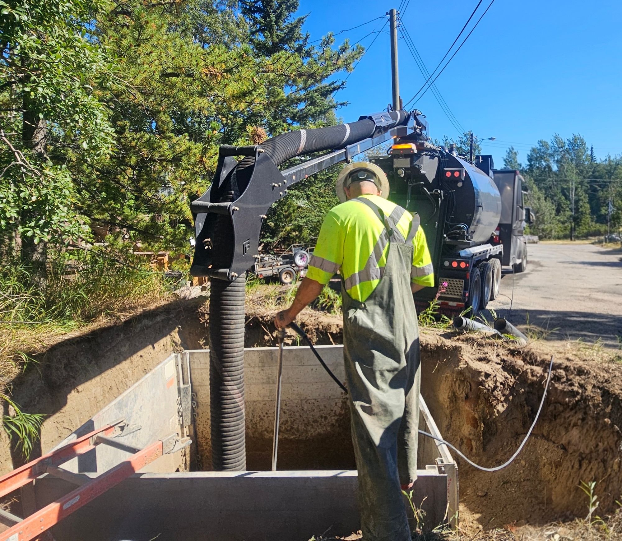 Laborer uses hydrovac wand to expose buried utilities
