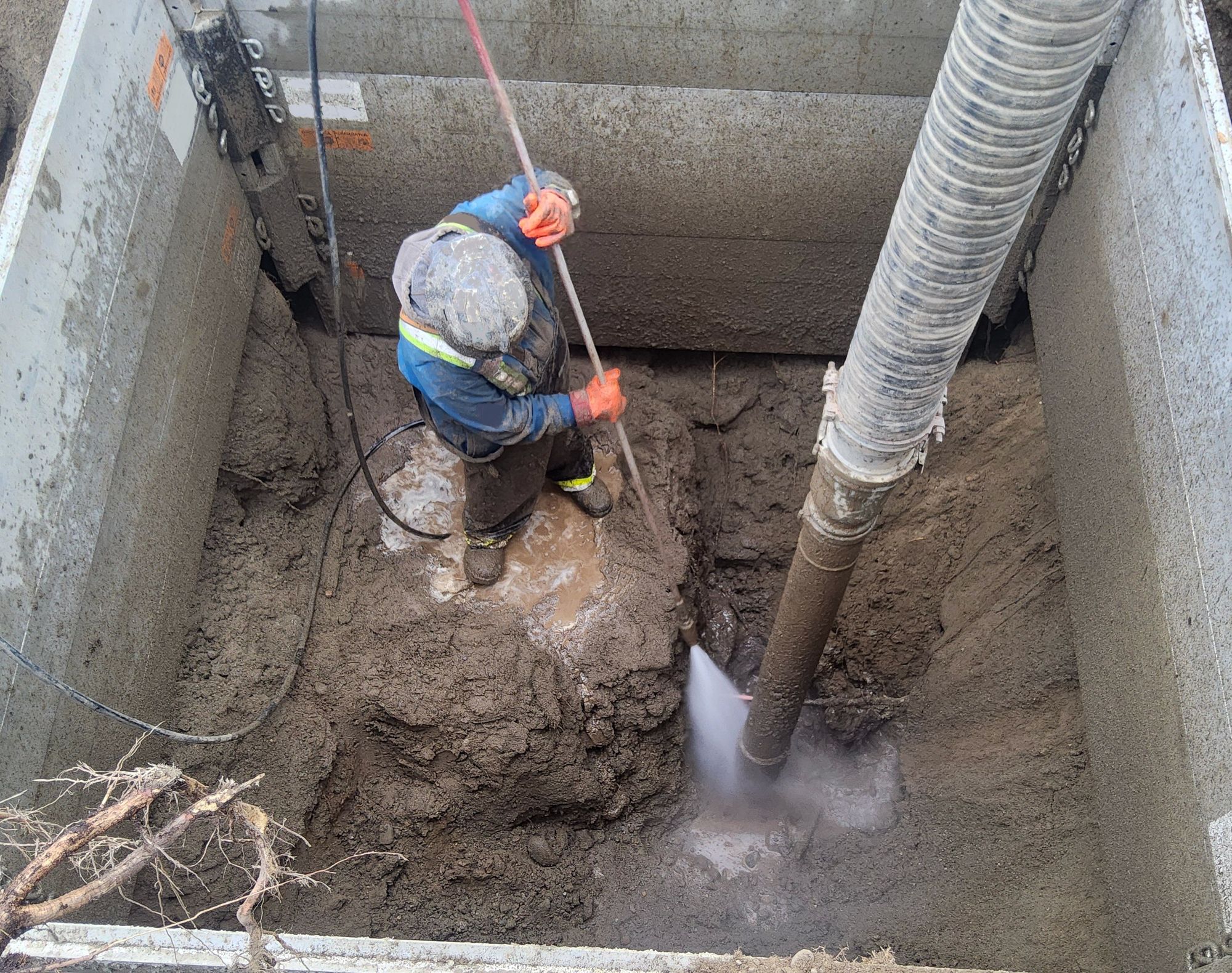 Civil worker uses hydrovac excavation to expose aged utilitie