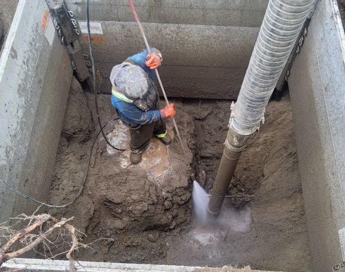 Civil worker uses hydrovac excavation to expose aged utilitie