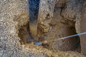 A worker uses hydroexcavation to repair utilities