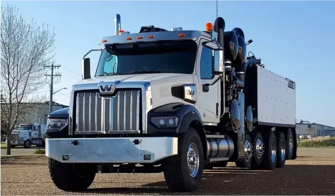 The front left quarter of a black and white hydrovac truck